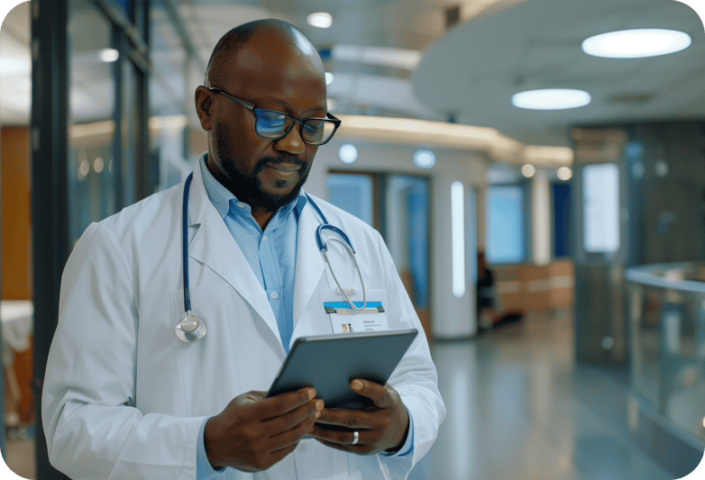 Male doctor, wearing a lab coat, holding a tablet in the hall of a psychiatric facility 