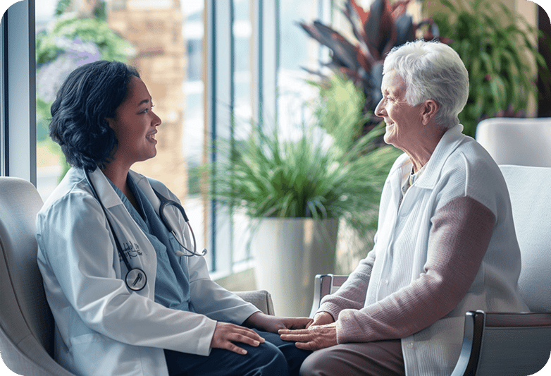 Female senior sitting next to her doctor in a senior care facility. Both women are smiling